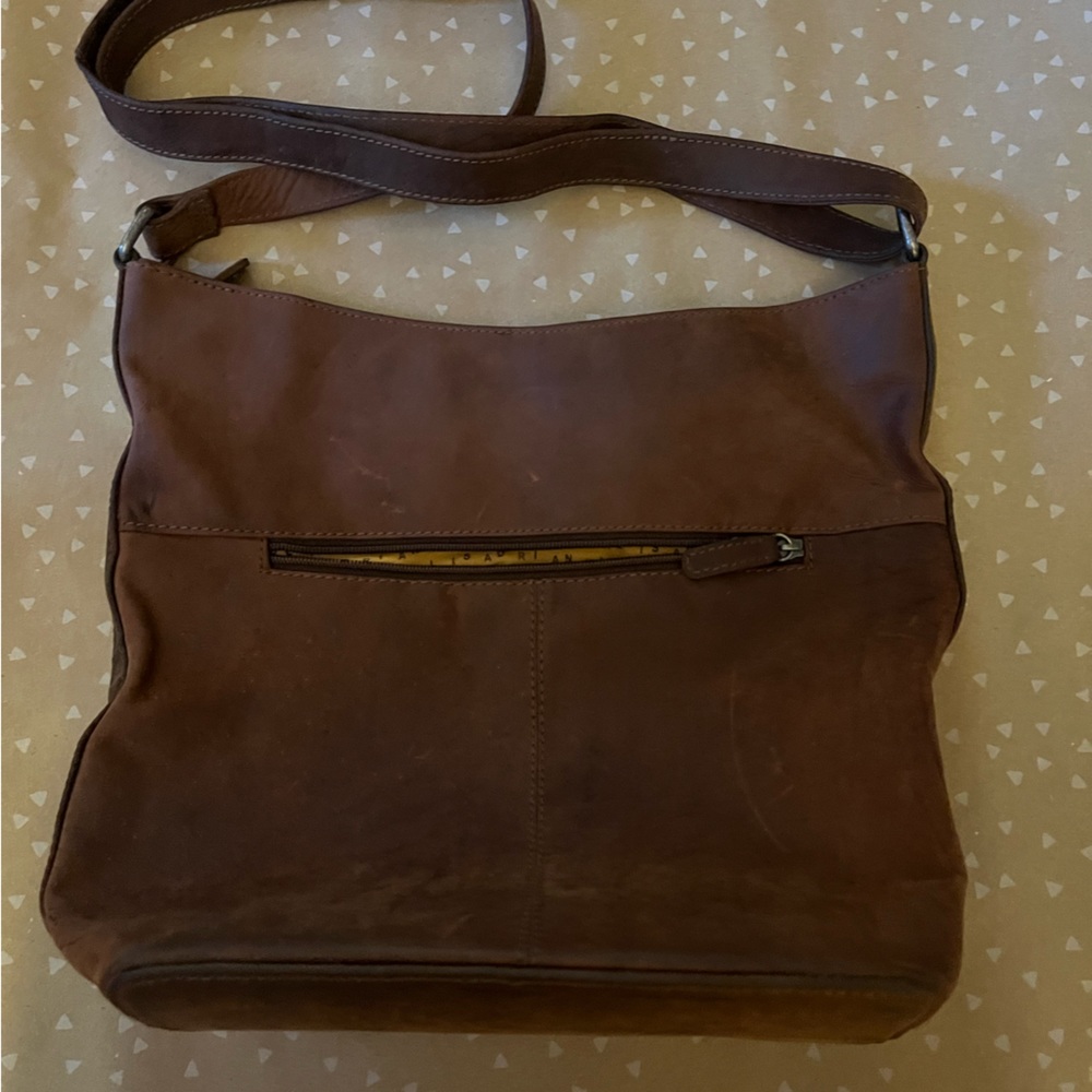 Adrian Klis purse brown leather with outside pocket and adjustable strap.